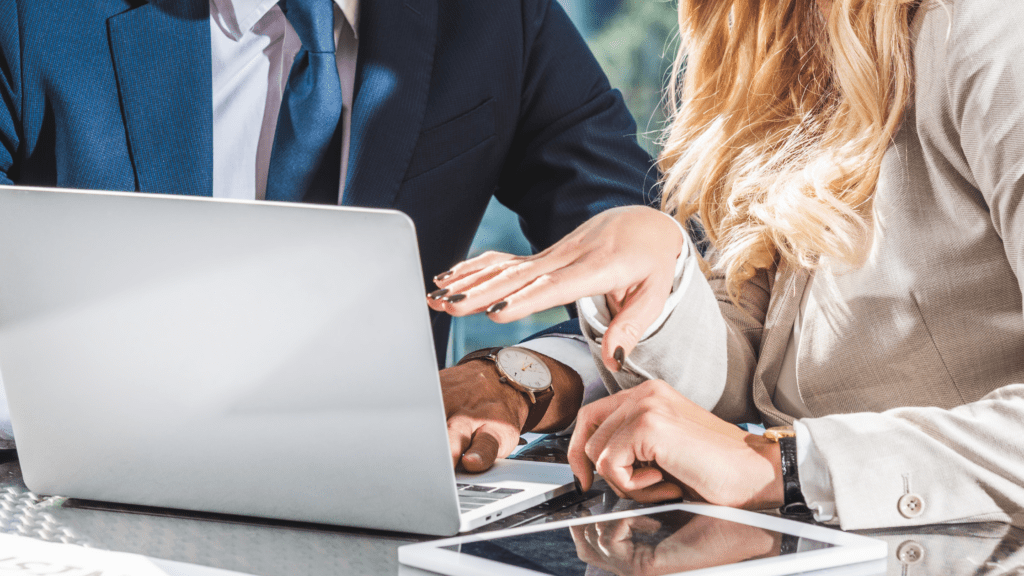 Colleagues looking at a laptop to demonstrate considering exit strategies