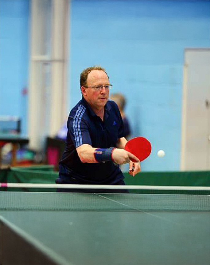 Finance professional playing table tennis at corporate social event