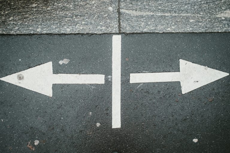 two arrows painted on the ground pointing in different directions
