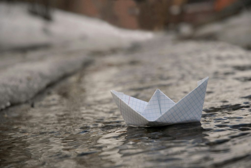 Photo of a paper boat on water to demonstrate how investors are like captains as they look at businesses and assess how invest-worthy they are
