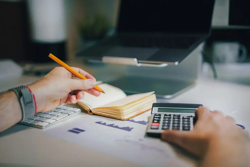 A business owners hand working on their budgets